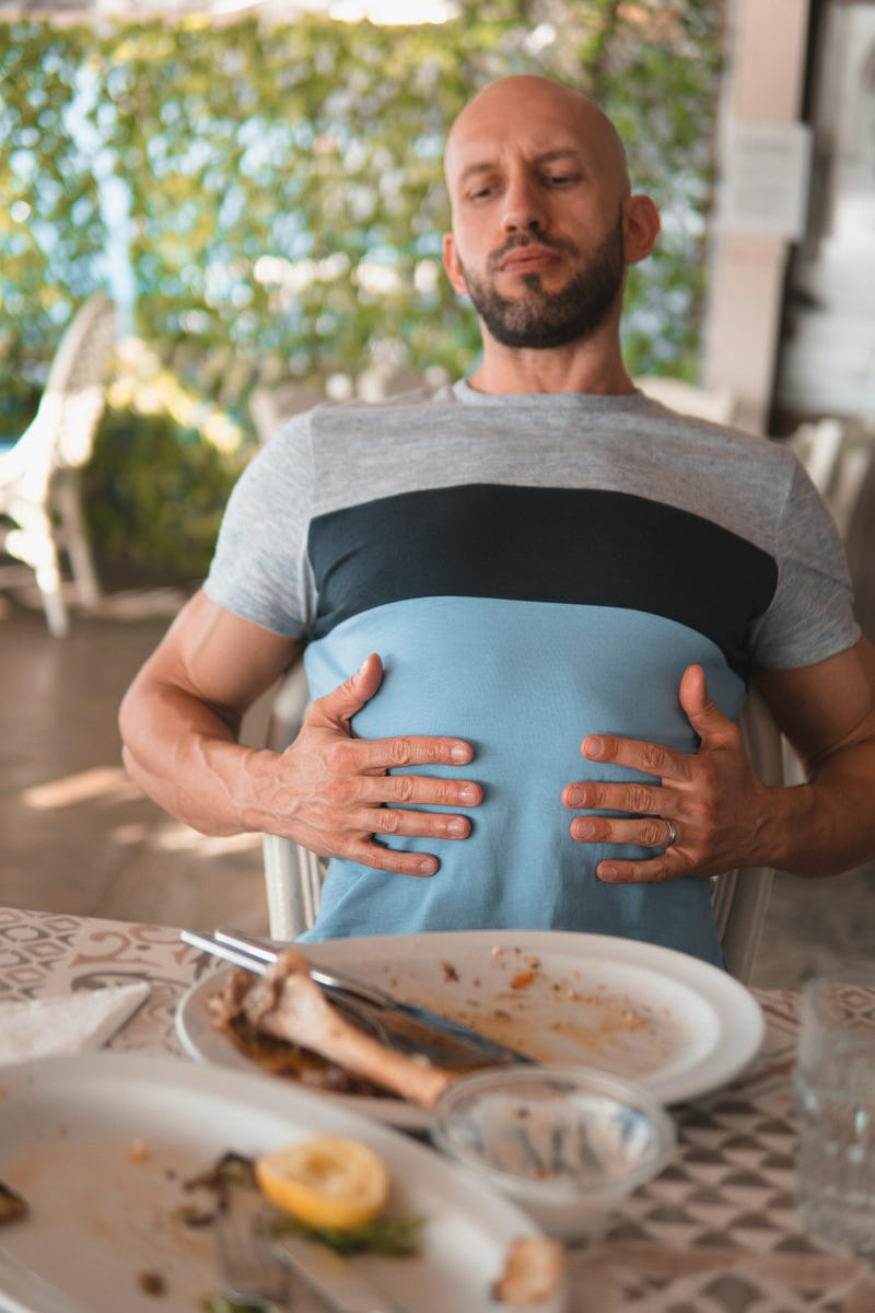 Man experiencing discomfort after overeating during Thanksgiving