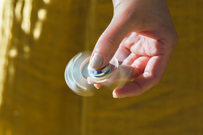 An adult fidgeting with various items during a video call